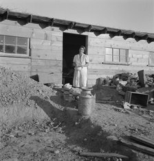Mrs. Dougherty in doorway of basement house, Warm Springs, Malheur County, Oregon, 1939. Creator: Dorothea Lange.