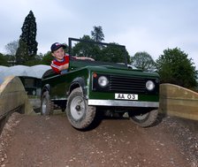 Child driving a toy Land Rover. Artist: Unknown.