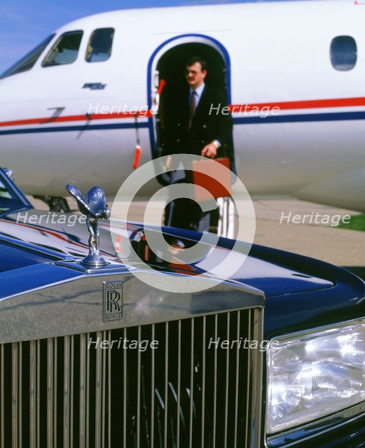 1987 Rolls Royce Silver Spirit with executive disembarking jet. Artist: Unknown.