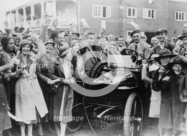 A 1904 Wolseley amidst a crowd of cheering people, Brooklands, Surrey, late 1920s-early 1930s. Artist: Unknown