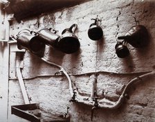 Measuring jugs and a funnel hung on a wall in the Red Cross pharmacy in London, c1890s. Creator: Unknown.