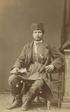 Full-length portrait of Persian man, seated, facing front, between 1870 and 1886. Creator: Unknown.