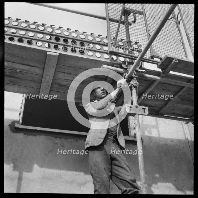 Builder working on the Penhill Estate, Swindon, Wiltshire, 1955. Creator: Unknown.