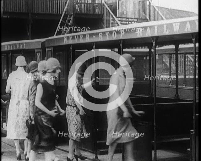 A Group of Female Civilians Board a Carriage of the 'Never Stop Railway', 1924. Creator: British Pathe Ltd.