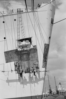 Workmen repairing the bow of a ship in London docks, c1945-c1965. Artist: SW Rawlings