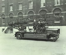 Firemen aboard a fire engine, London Fire Brigade Headquarters, London, 1929. Artist: Unknown.