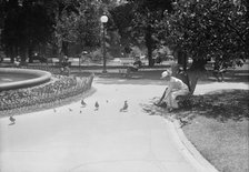 District of Columbia Parks - Feeding Pigeons in The Parks, 1917. Creator: Harris & Ewing.