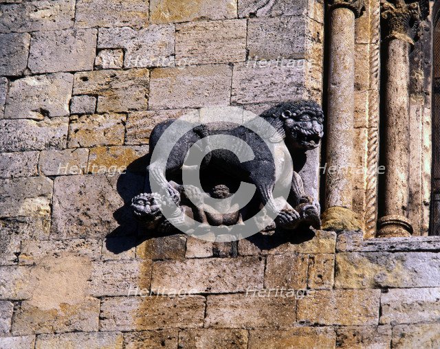 Church of San Pedro de Besalu, lion protecting a human figure and decorating the front window of …