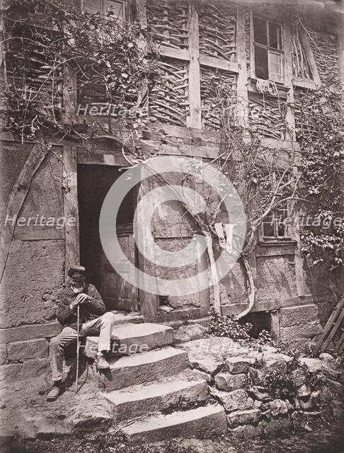 [Man Sitting on Steps of House with Socks Hanging on Nearby Vine to Dry], 1880s. Creator: Unknown.