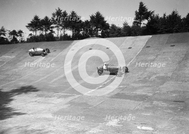 Two Bugatti Type 35s racing on the Members Banking at Brooklands. Artist: Bill Brunell.