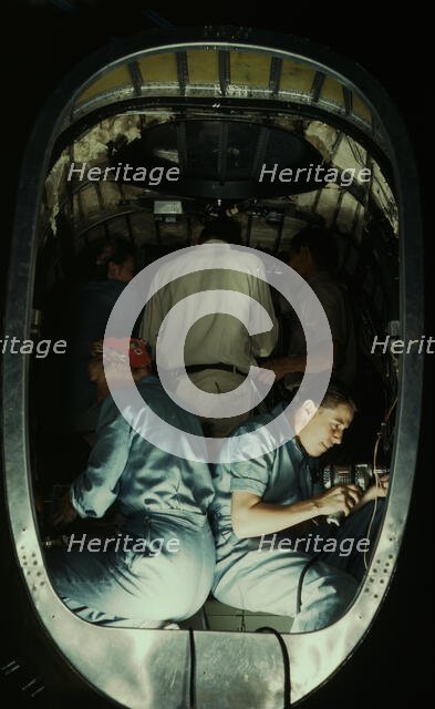Working inside fuselage of a Liberator Bomber, Consolidated Aircraft Corp., Fort Worth, Texas, 1942. Creator: Howard Hollem.