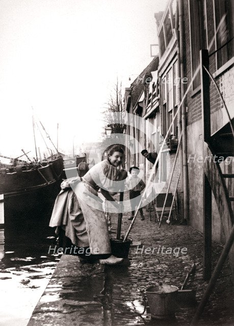 Woman mopping the street, Dordrecht, Netherlands, 1898.Artist: James Batkin