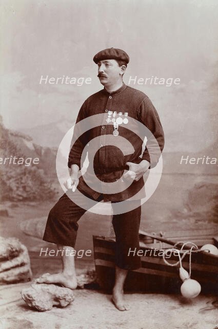 A barefoot Basque fisherman posing with several medals on his tunic, undated, estimated c1900s. Creator: Unknown.
