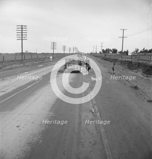 Passing motorist gives walking family of seven a lift to the next town, California, 1939. Creator: Dorothea Lange.