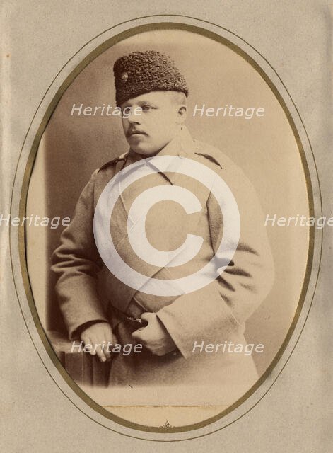 A young man in a fireman's uniform (overcoat and hat), late 19th cent - early 20th cent Creator: Shnee.