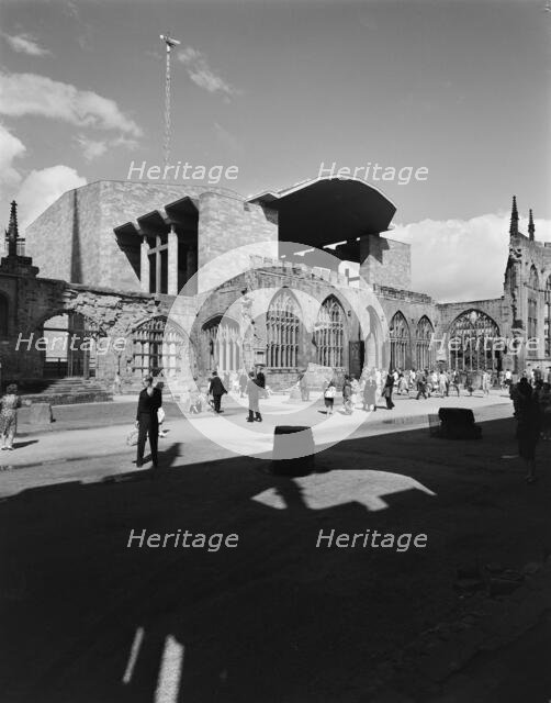 People exploring the ruins of the Cathedral Church of St Michael, Coventry, 1962.  Creator: John Laing plc.