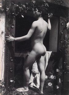 A Sicilian male, posing naked outdoors, by a doorway, c1900. Creator: Guglielmo Pluschow.