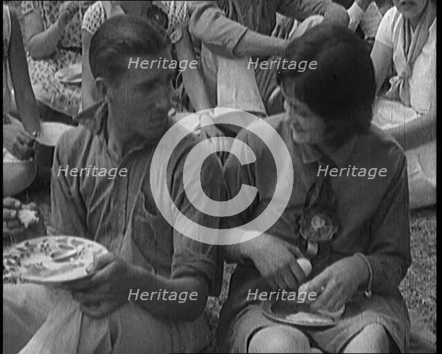 Male Civilian and Female Civilian Enjoying a Picnic Outdoors, 1920. Creator: British Pathe Ltd.