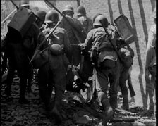 A Group of Male Japanese Soldiers Pushing a Gun Over Rubble in a Street in Shanghai, 1937. Creator: British Pathe Ltd.