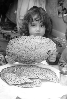 Jewish child holding Passover matzot, Edgware, London, 29 March 1991. Artist: John Nathan