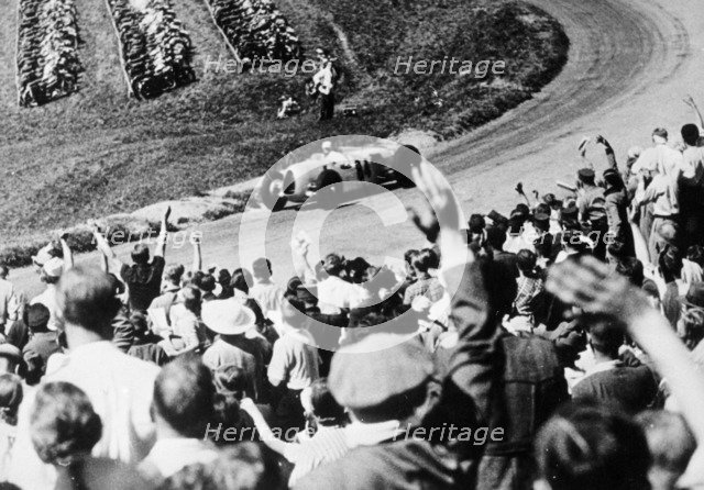 Bernd Rosemeyer acclaimed by the crowd, German Grand Prix, Nurburgring, 1936. Artist: Unknown
