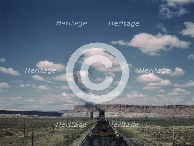 A freight train stopping for coal and water at a siding enroute to Gallup, New Mexico, 1943. Creator: Jack Delano.