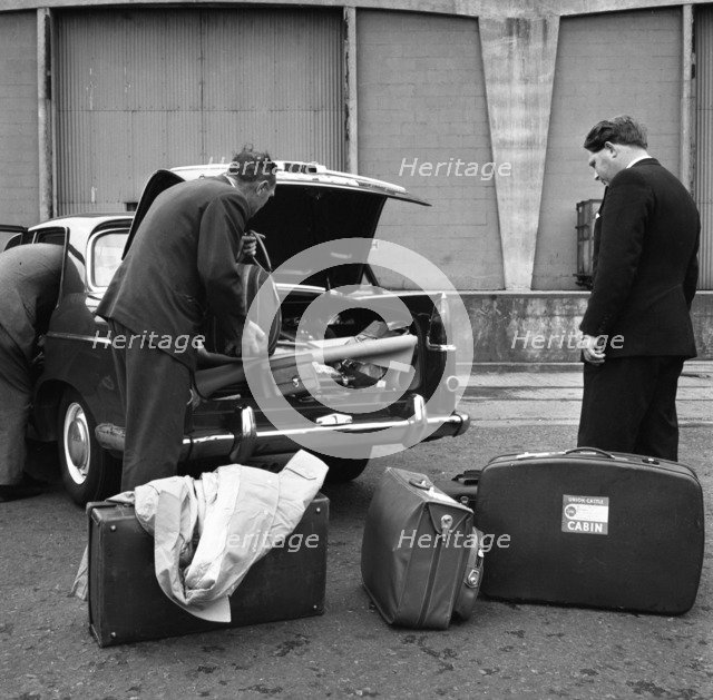A 1961 Austin Westminster being loaded with luggage on Amsterdam docks, Netherlands 1963. Artist: Michael Walters