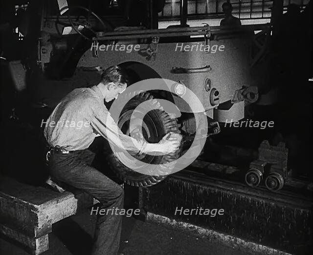 A Worker Fitting Wheels on a Car at an American Factory , 1942. Creator: British Pathe Ltd.