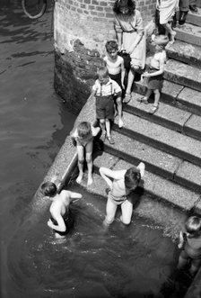 Children bathing in the River Thames, Tower Pier approach, Stepney, London, c1945-c1965. Artist: SW Rawlings