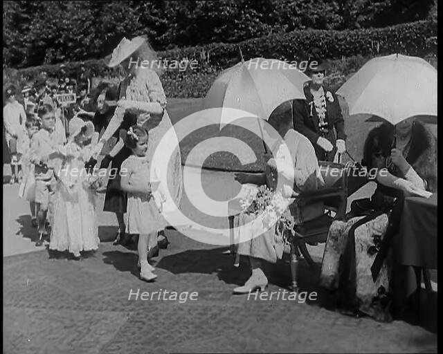 A Young British Girl Approaching the Chair of Queen Mary of Teck With a Purse in Her Hand..., 1939. Creator: British Pathe Ltd.
