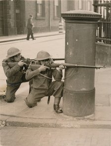 The Home Guard find cover behind a pillar box during a enemy engagement rehearsal, 1941. Artist: Unknown