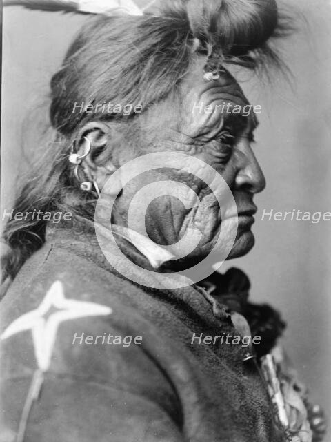 Hoop On the Forehead, Crow Indian, Montana, head-and-shoulders portrait, facing right, c1908. Creator: Edward Sheriff Curtis.