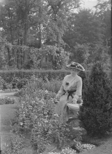 Truesdale, W., Mrs., standing in a garden, 1915 July 6. Creator: Arnold Genthe.