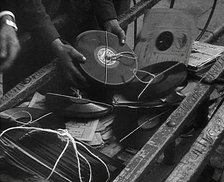 A Man Dumping Old gramophone records to Use for War Materials, 1942. Creator: British Pathe Ltd.