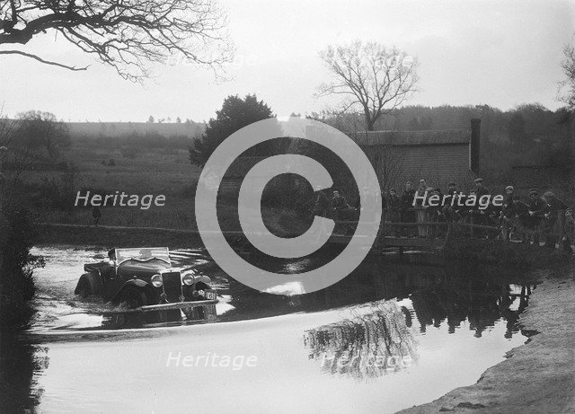 Hillman Aero Minx open 2-seater driving through a ford during a motoring trial, 1936. Artist: Bill Brunell.