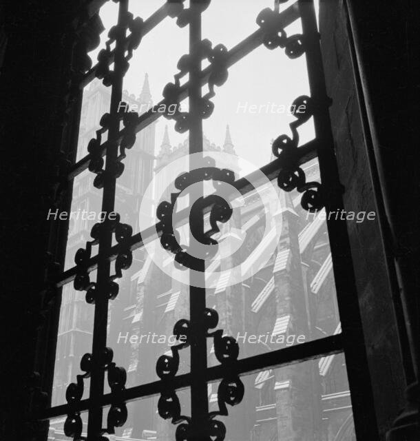 View through a wrought iron window grille towards the south facade of Westminster Abbey, 1947-57. Creator: John Gay.