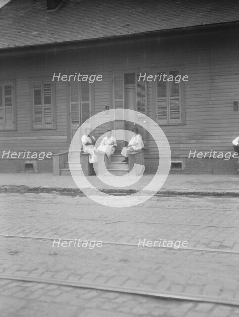 View from across street of three women talking, New Orleans or Charleston, South Ca., c1920-c1926. Creator: Arnold Genthe.