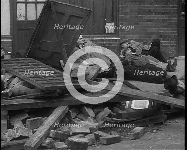 British People Acting Out Bomb attacks and Crashed German Planes, Lying Under Rubble, 1940. Creator: British Pathe Ltd.