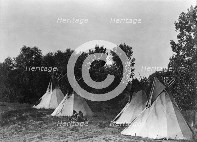 An Assiniboin camp containing four tepees with Indians seated on ground, c1908. Creator: Edward Sheriff Curtis.