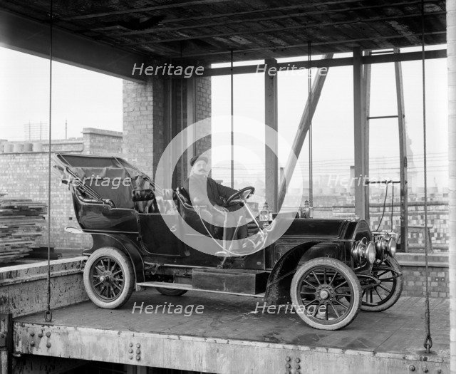 A car and chauffeur in the car lift at Mitchell's Motors, Wardour Street, London, 1907. Artist: Bedford Lemere and Company