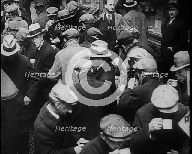 Small Crowd of Men Standing Outside in a Crowded Space, 1933. Creator: British Pathe Ltd.