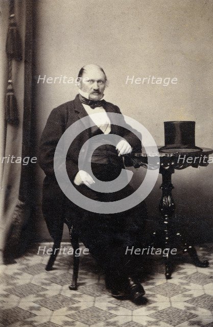 Studio portrait of a man at a table with a top hat, c1865. Artist: Unknown
