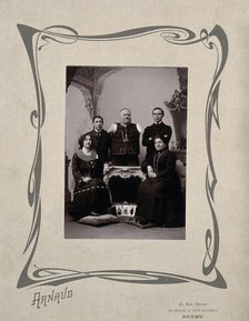 A family portrait: a man without arms and legs poses on a table surrounded by family, 20th Century. Creator: Unknown.