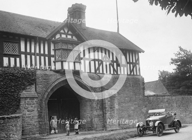 Singer 10 hp open 2-seater by the gatehouse of Stokesay Castle, Shropshire, 1920s. Artist: Bill Brunell.