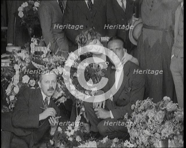 Mary Pickford and Douglas Fairbanks Senior Sitting Together Amongst a Bed of Flowers in Paris, 1920. Creator: British Pathe Ltd.