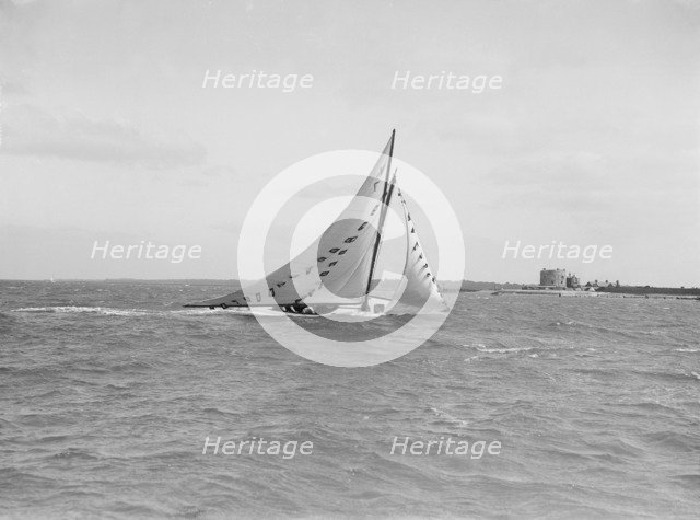 The 7 Metre 'Ginerva' (K7) under sail with prize flags, 1912. Creator: Kirk & Sons of Cowes.