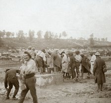 Soldiers queuing in the mud for water, Genicourt, northern France, c1914-c1918. Artist: Unknown.