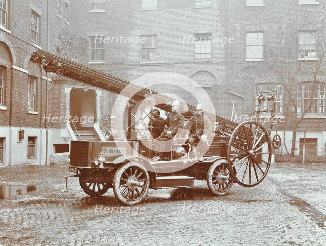 Firemen aboard a motor fire escape vehicle, London Fire Brigade Headquarters, London, 1909. Artist: Unknown.