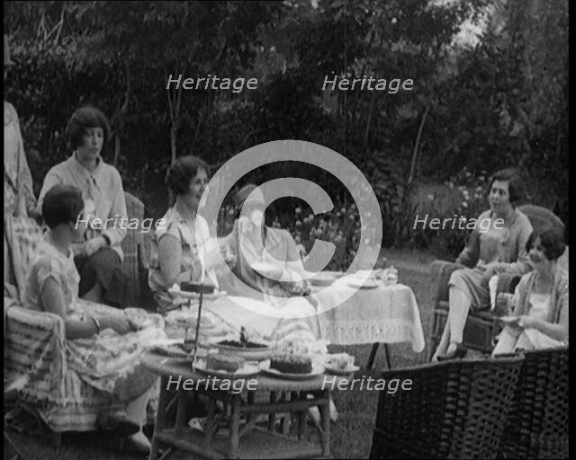 A Group of Female Civilians Drinking Tea and Eating Cakes in the Garden, 1926. Creator: British Pathe Ltd.