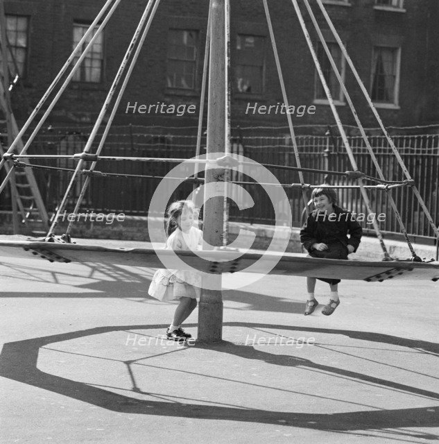 Girls playing on a 'witch's hat' in a playground, London, 1960-1965. Artist: John Gay